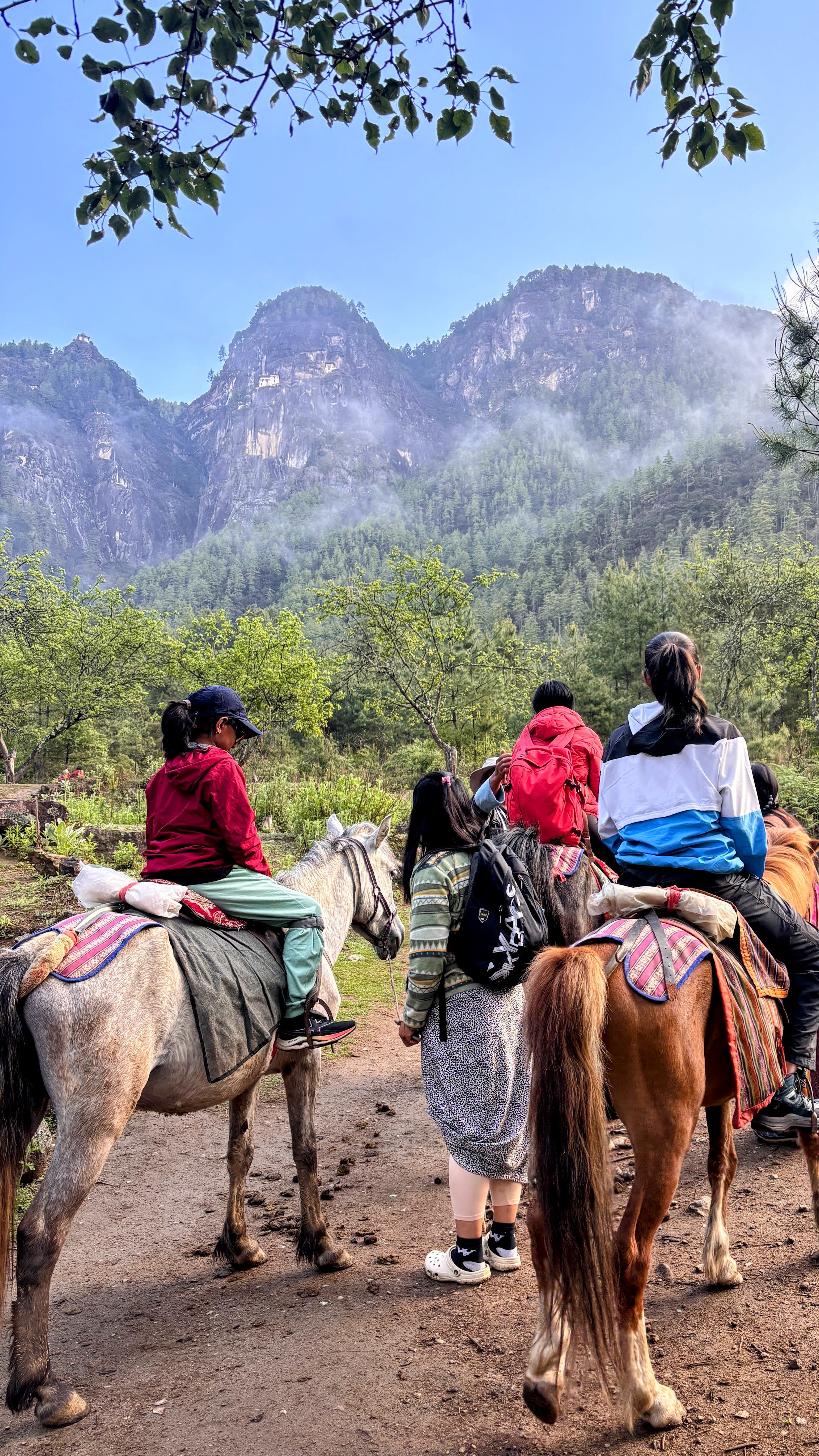 Kids ready on horse backs, with the Tiger Nest in sight right at the top of the mountain