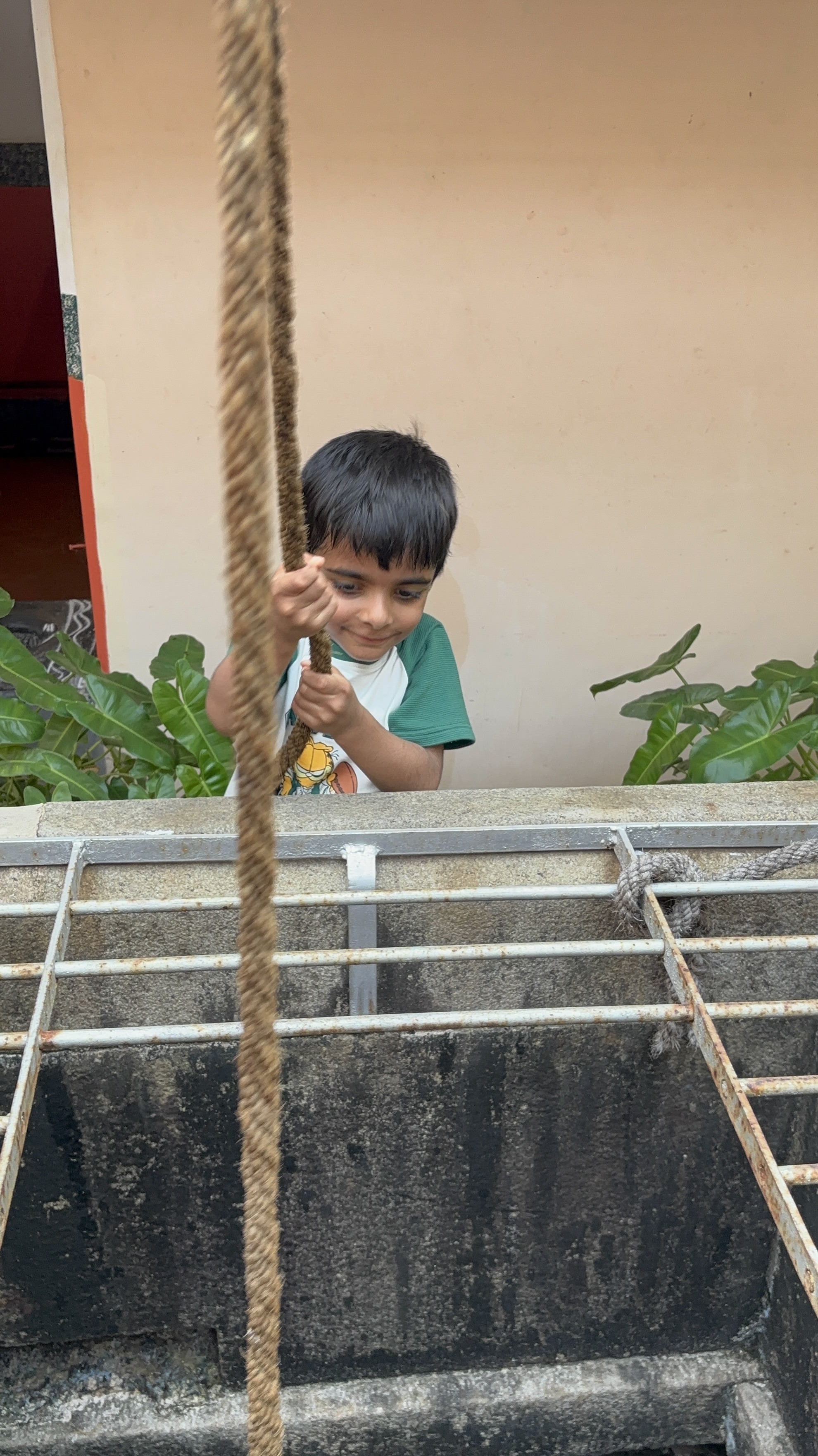 Dropping the bucket to fetch water from the water well at the Vila