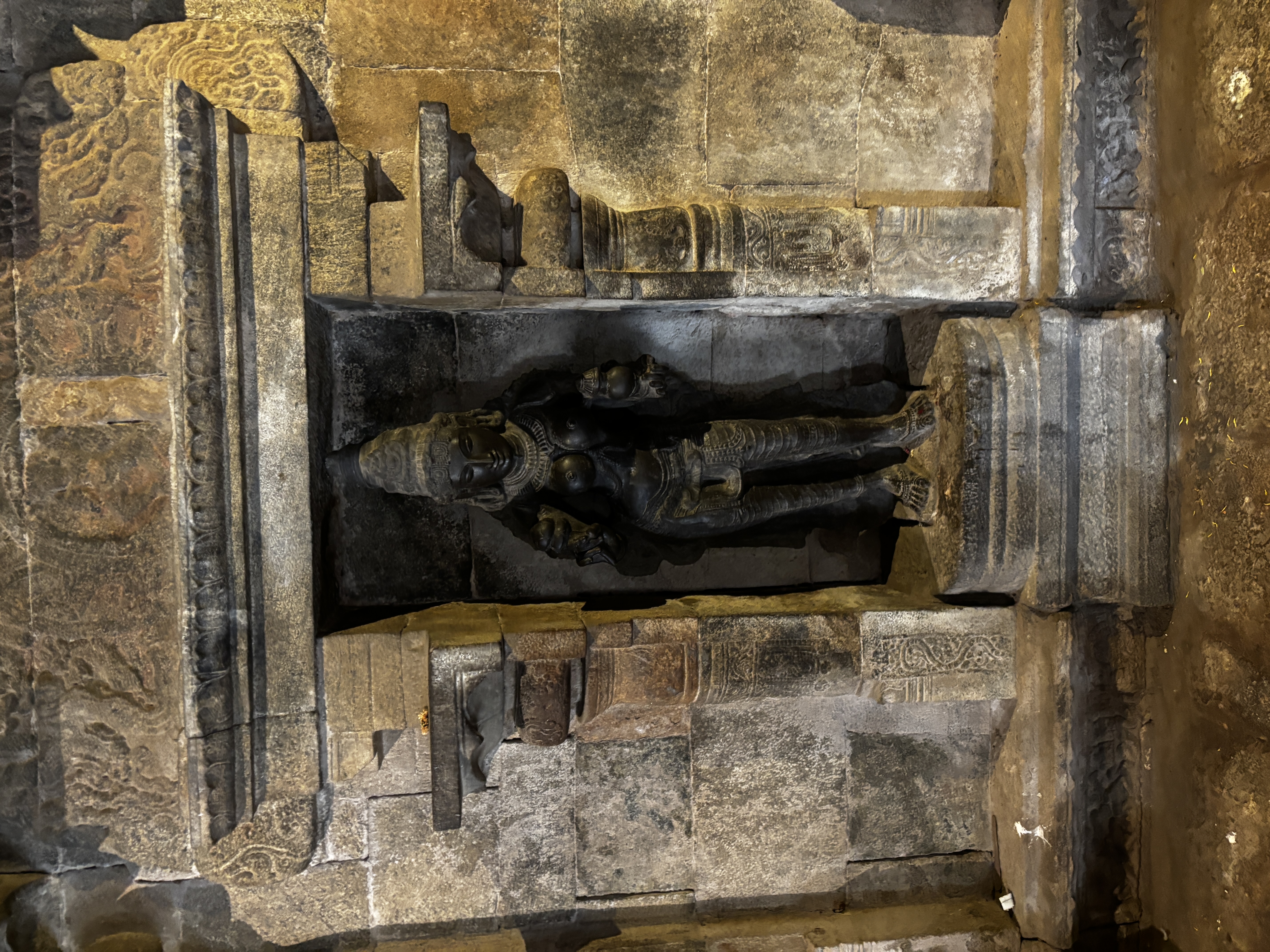Lakshmi idol in black stone with finer details like bichia (toe rings). nails and a clearly visible neck thread that was worn by married women